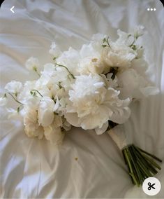 a bouquet of white flowers laying on top of a bed