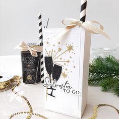 a card with two champagne glasses on it next to some christmas decorations and a candle