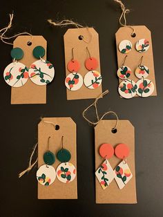 six different earrings are hanging from brown tags