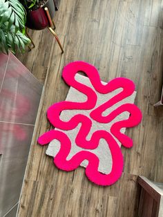 a pink and white rug on the floor next to a potted plant