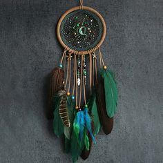 a dream catcher hanging on the wall with beads and feathers attached to it's sides