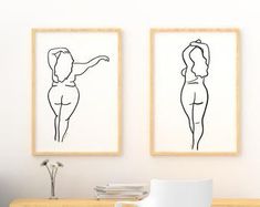 two black and white drawings on the wall above a desk