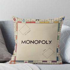 a monopoly board game throw pillow sitting on top of a couch with the word monopoly printed on it