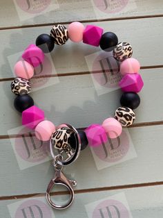 "**Ready to Ship ** Beaded pink/black leopard Bangle wristlet Keychain.  This  Bangle wristlet Keychain fits easily over the wrist.  You roll it on and off.  This Keychain is not elastic.   One size fits most.  Opening is approximately 3.5\".  If a bigger size is needed, I can make it so for $1.00 additional.   Never loose your keys again  Made of silicon beads  Follow me on Facebook for new and upcoming items. https://www.facebook.com/Jeminisdesigns  Please read the full policies before purchase." Pink Jewelry With Adjustable Black Beads, Pink Beaded Bracelets As Fashion Accessory, Pink Wristlet With Lobster Clasp For Gifts, Trendy Pink Wristlet With Keychain, Pink Beaded Bracelets With Lobster Clasp, Pink Beaded Bracelets With Round Beads, Silicon Beads, Keychain Beaded, Pink Keychain