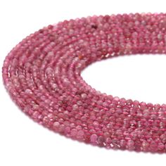 pink seed beads are arranged on a white surface