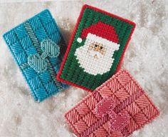 two crocheted coasters with santa's face on them