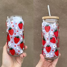 two hand painted strawberries and daisies in a mason jar with strawberries on it