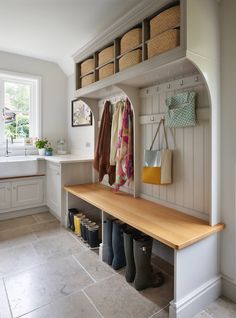 a wooden bench sitting under a window next to a sink and cabinets in a kitchen