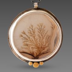 A very special dendritic agate evokes a mysterious and lovely scene in nature. The stone is wrapped in sterling silver and accented with a hammered 22k gold trio. Each of these incredible stones is one of a kind, and completely natural. Pendant measures approximately 7/8 inch in diameter, and is suspended from an oxidized sterling silver chain. Matte finish. This piece is in stock and ready to ship. Earthy Style Gold Agate Jewelry, Earthy Gold Agate Jewelry, Unique Engraved Agate Jewelry, Oval Agate Necklace With Nature-inspired Style, Nature-inspired Jewelry With Natural Inclusions In Round Pendant, Unique Gold Agate Necklaces, Nature-inspired Oval Agate Necklace, Gold Moss Agate Pendant Jewelry, Nature-inspired Oval Agate Jewelry