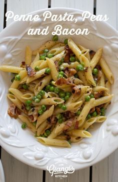 penne pasta, peas and bacon in a white bowl on a wooden table with text overlay