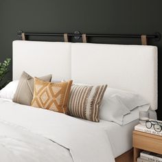 a bed with white linens and pillows on it