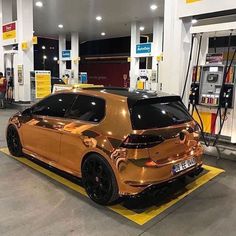 a gold car is parked at a gas station