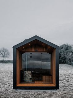 a small wooden structure in the middle of a field