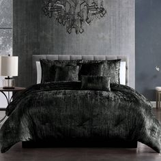 a black and white bedroom with chandelier above the bed in front of it