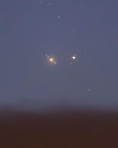 three planets are seen in the sky at night, with one light shining on them