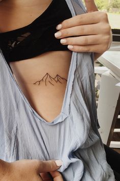 a woman with a mountain tattoo on her stomach