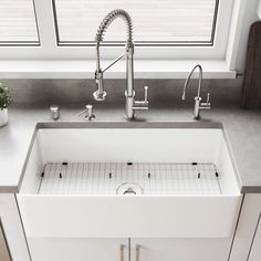 a white kitchen sink sitting under a window next to a potted plant on top of a counter