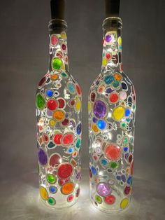 two glass bottles with different colored circles on them