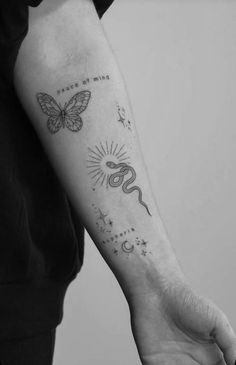 a person with a butterfly tattoo on their arm and the word love is written in black ink