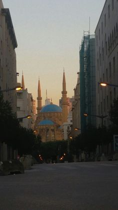 a city street with tall buildings and a blue dome on the top of one building