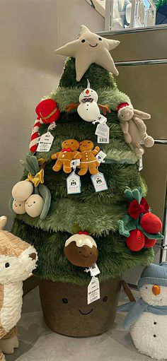 a small christmas tree with stuffed animals around it