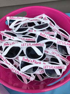 several pairs of sunglasses are in a pink bowl