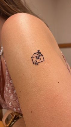 a woman with a small house tattoo on her arm