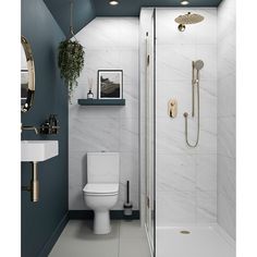 a white toilet sitting in a bathroom next to a sink and shower with gold fixtures