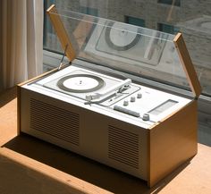 an old record player sitting in front of a window