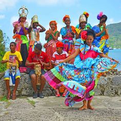 a group of people standing next to each other in front of a body of water