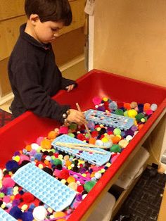 a young boy playing with legos in a play room