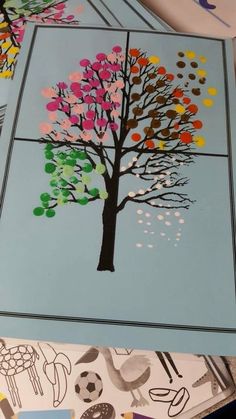 a tree made out of colored paper on top of a table next to scissors and markers