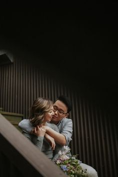 a man and woman embracing each other on the stairs