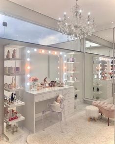 a room with a vanity, mirror and lights on it's walls in front of a large window