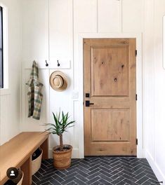 an entryway with a wooden door and potted plant