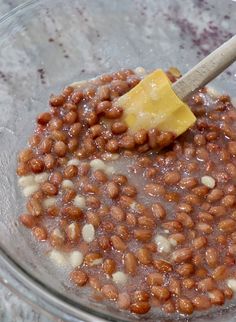 a glass bowl filled with baked beans and butter