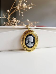 "Golden Brass Medallion locket necklace, an elegant oval shaped pendant for gift giving or as a family keepsake. The locket has a deep rich golden color and it has a black vintage style lady cameo on the front. Feminine lace-like details on edge.  Keep something special in this locket for yourself, or give this piece as a gift to an dear person in your life.  The oval locket opens and closes,  revealing an empty space for you to add a photo, a secret message, a quote or even something small ( pe Cameo Locket, Locket Necklace Vintage, Gold Locket Necklace, Black Lady, Oval Locket, Cadeau Photo, Symbolic Jewelry, Photo Necklace, Family Keepsakes