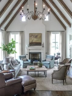 a living room filled with lots of furniture and a chandelier hanging from the ceiling