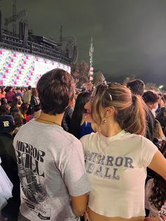 two people standing next to each other at a concert