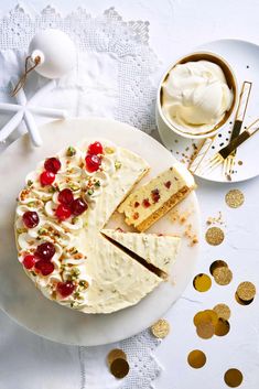 a cake with white frosting and cherries on it next to some gold confetti