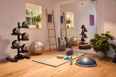 an exercise room with yoga mats, balance balls and other personal care items on the floor