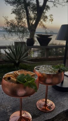 two glasses filled with drinks sitting on top of a table