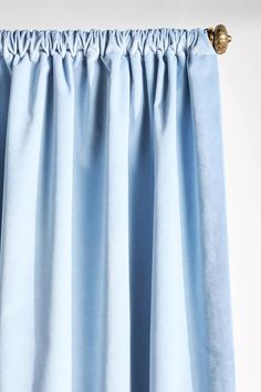 a blue curtain hanging on the side of a window