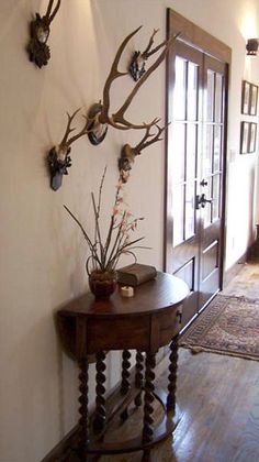 an entry way with antlers on the wall and a table in front of it