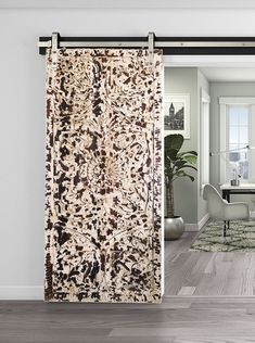 a living room with an area rug on the floor and sliding glass door to another room