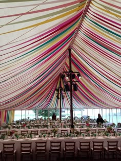 the inside of a tent with tables and chairs