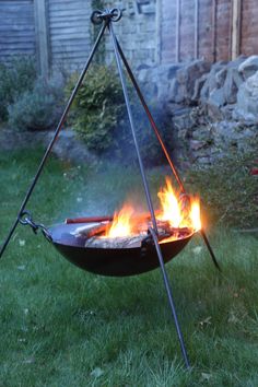 a fire pit sitting in the middle of a yard with two sticks sticking out of it