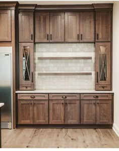 a kitchen with wooden cabinets and white tile backsplash