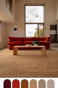 a living room with red couches and brown rugs in front of a large window