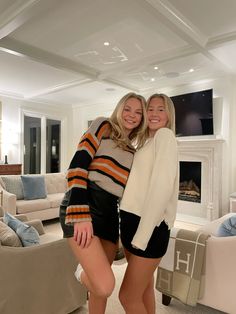 two women standing next to each other in a living room